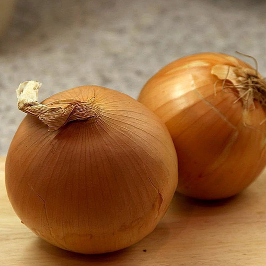 Two whole yellow sweet Spanish onions on a wooden surface.