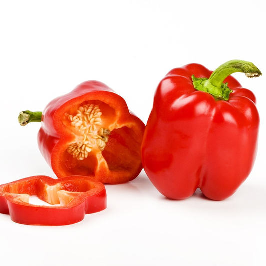 A whole red bell pepper next to a sliced red bell pepper showing the inside with seeds.